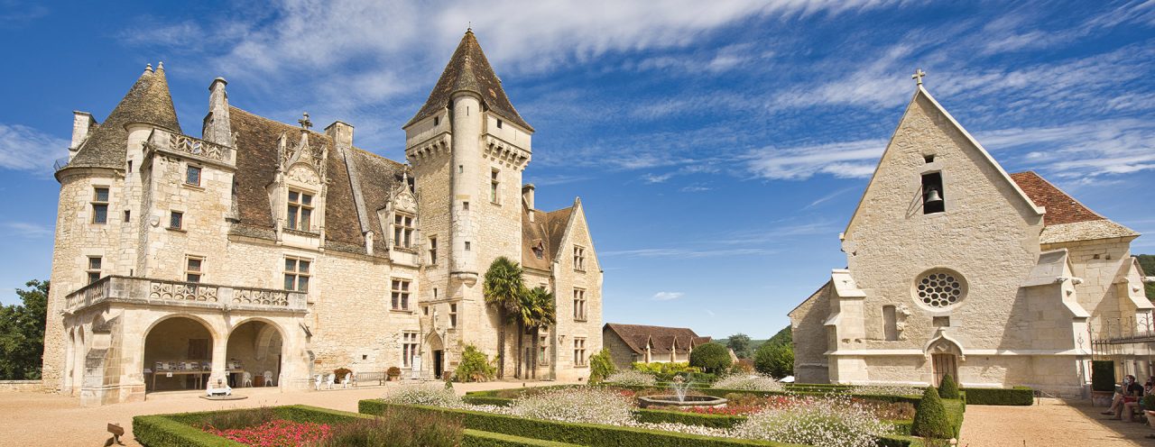Vue du Château des Milandes, flanqué d'un jardin fleuri en façade