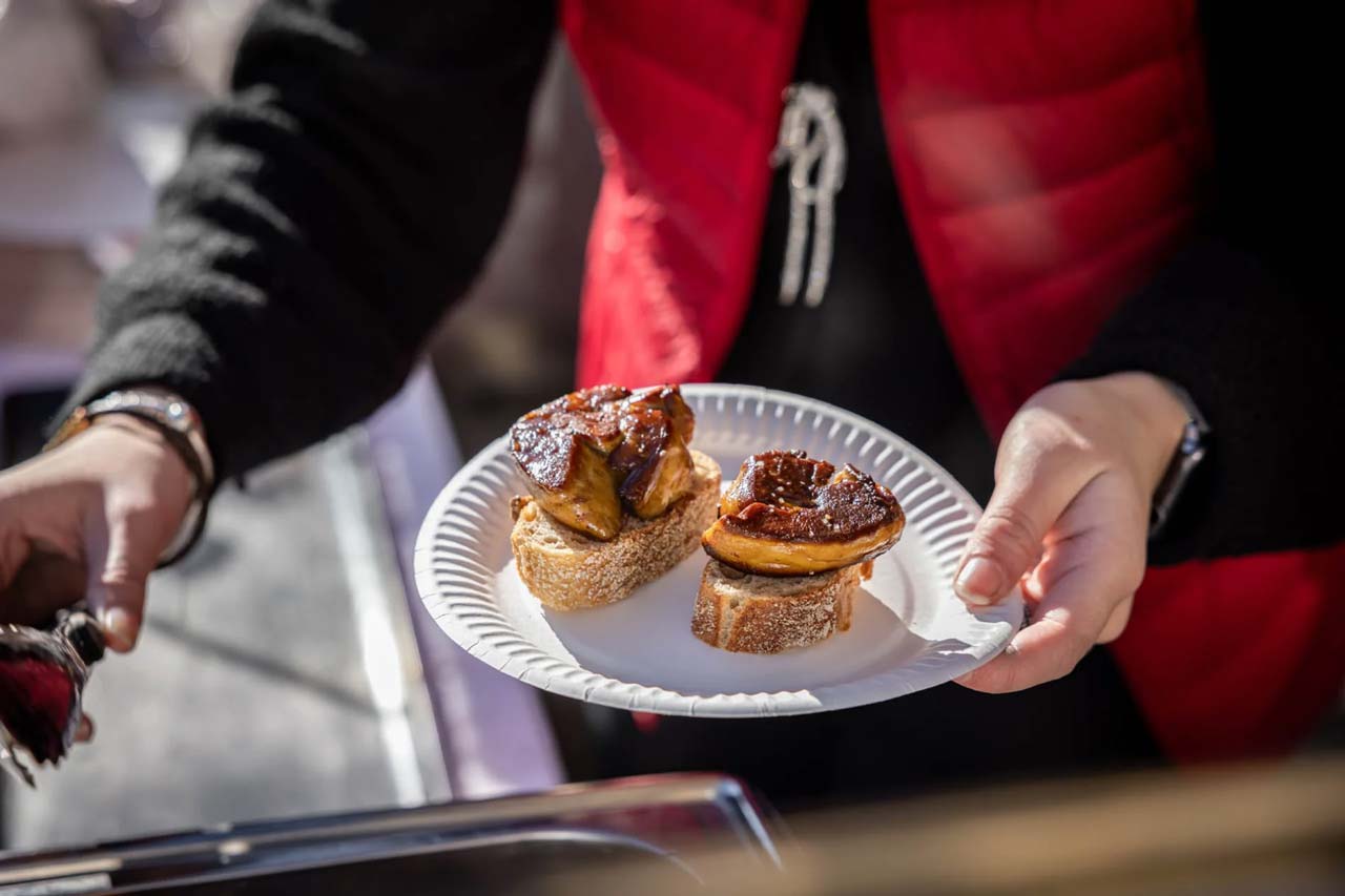 Une personne tenant une assiette remplie de toast de foie gras poêlé.